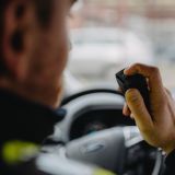 Ein Polizeibeamter im Streifenwagen spricht ins Funkgerät