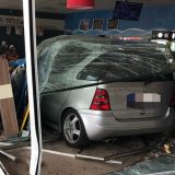 Auto im Tankstellen-Innenraum hinter gesplitterter Scheibe