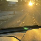 Blick aus dem Cockpit eines Autos auf tiefstehende Sonne
