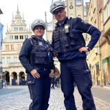 Eine Polizeibeamtin und ein Polizeibeamter vor dem Historischen Rathaus von Münster