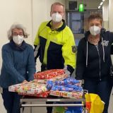 Vier Personen schieben einen Geschenkwagen durch einen Klinik-Flur