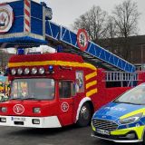 Ein Polizeiwagen und ein Karnevalswagen in Form eines Feuerwehrautos