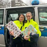 Das Bild zeigt Kerstin Hagemann und Theresa Brinkmann mit zwei Geschenken für die Kinderneurologie.