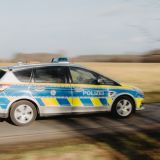 Ein Streifenwagen fährt auf einer Landstraße