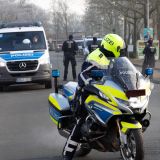 Motorradpolizist und Einsatzwagen der Polizei