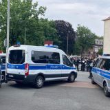 Einsatzfahrzeuge der Polizei, im Hintergrund Hundertschaftskräfte
