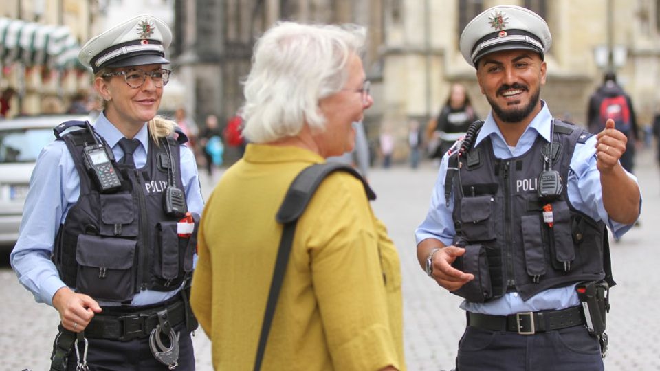 Symbolbild Polizisten mit Bürgerin