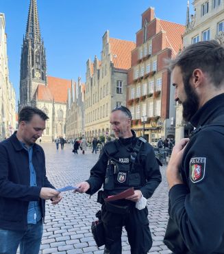 Foto: Polizei Münster (Polizisten verteilen Informationsflyer)