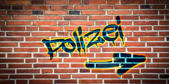 Polizei Graffiti auf roter Mauer